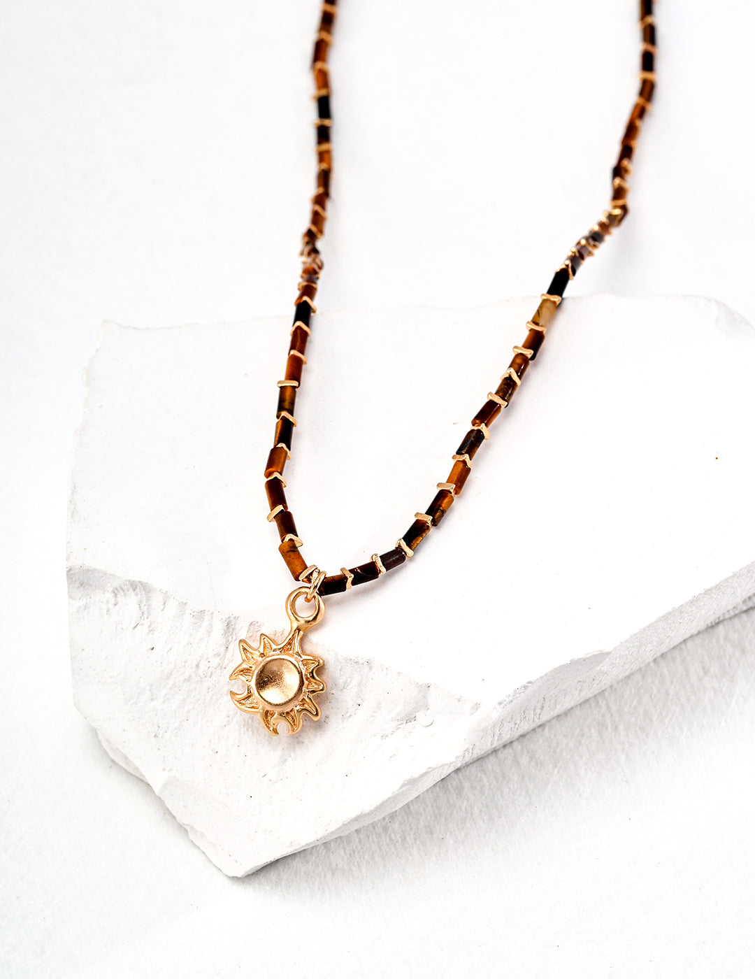 Tiger eye necklace with a radiant sun pendant, showcasing warm, earthy tones and elegant design.